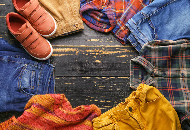 Czyste ubrania dla dzieci z butami na drewnianym stole - Zdjęcie, obraz
