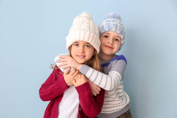 Cute children in winter clothes on color background - Foto, Imagem