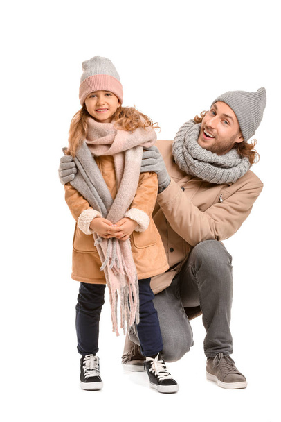Handsome man and his little daughter in winter clothes on white background - Фото, зображення
