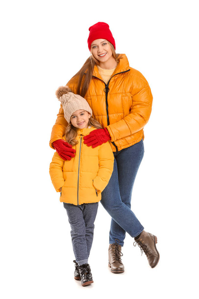 Frau und ihre kleine Tochter in Winterkleidung auf weißem Hintergrund - Foto, Bild