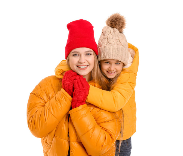 Woman and her little daughter in winter clothes on white background - Photo, Image