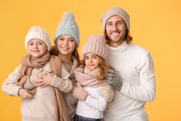 Happy family in winter clothes on color background - Φωτογραφία, εικόνα