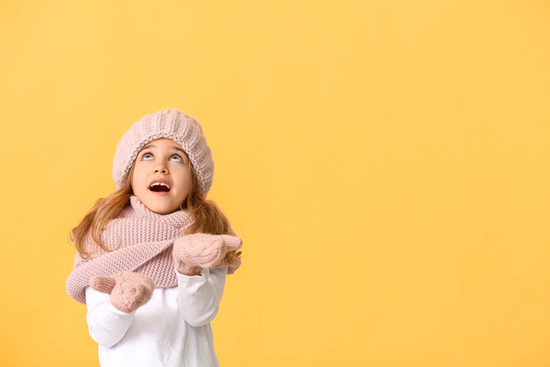 Little girl in winter clothes on color background - Foto, Imagem