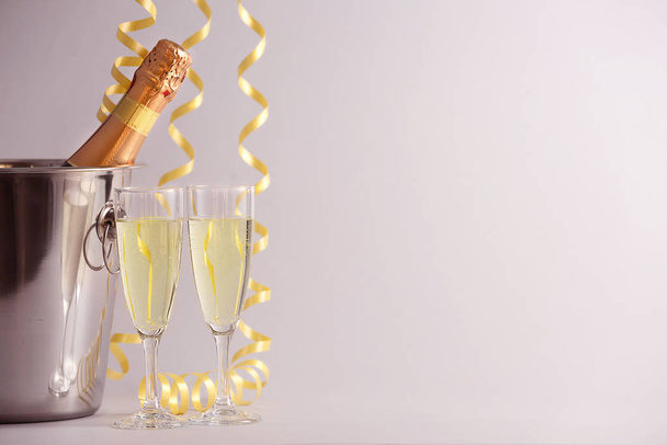 Відро з пляшкою шампанського, окулярами та різдвяним декором на світлому фоні
 - Фото, зображення
