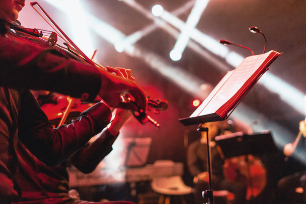 Červené barevné housle koncert na světlé rockové scéně - Fotografie, Obrázek