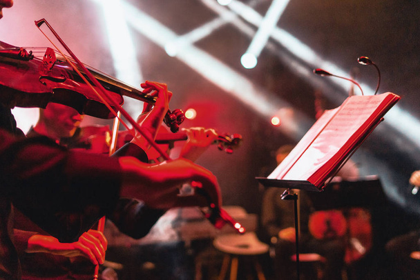 Συναυλία βιολιού με κόκκινο χρώμα στο φωτεινό ροκ στάδιο - Φωτογραφία, εικόνα