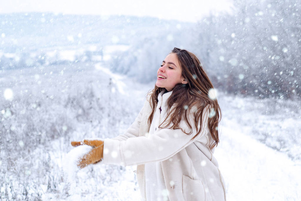 Woman in snow. Snowball game. Playing with snow and having fun in winter park. Activity smiling girl in winter travel. Snowball game in winter holiday. Enjoying the weather and snow. - Zdjęcie, obraz