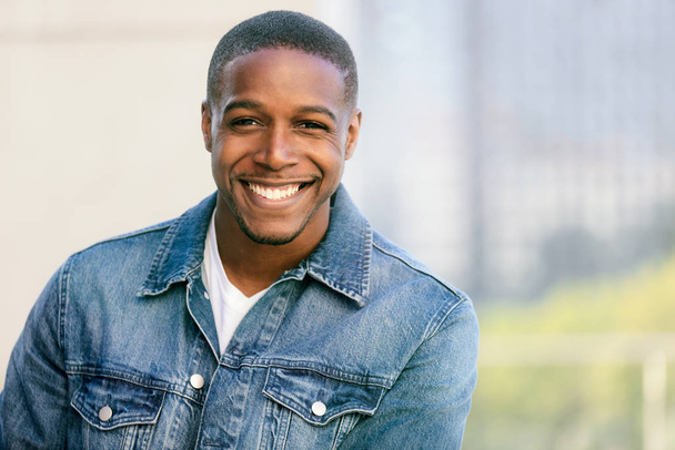 Close up head shot of a handsome commercial african american model with perfect white teeth smile after dentist, dental and orthodontic advertisement - Foto, Imagem