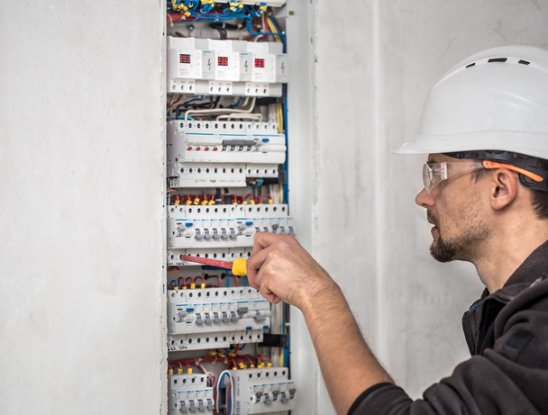 Man, an electrical technician working in a switchboard with fuse - Foto, immagini