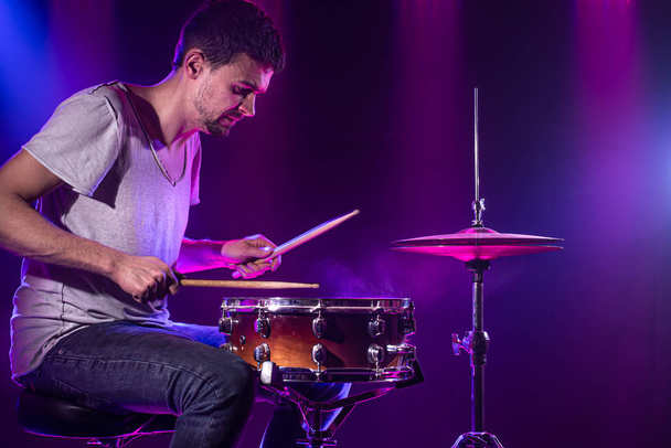 Барабанщик играет на барабанах. Красивый синий и красный фон
,  - Фото, изображение