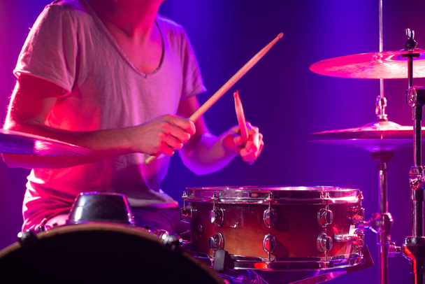 The drummer plays the drums. Beautiful blue and red background,  - 写真・画像