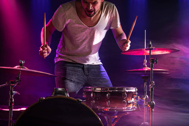 El baterista toca la batería. Hermoso fondo azul y rojo
,  - Foto, imagen