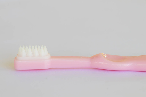  escova de dentes do bebê 8 meses de idade cuidados de saúde cavidade oral do arranjo do bebê flat lay estilo no fundo branco
  - Foto, Imagem