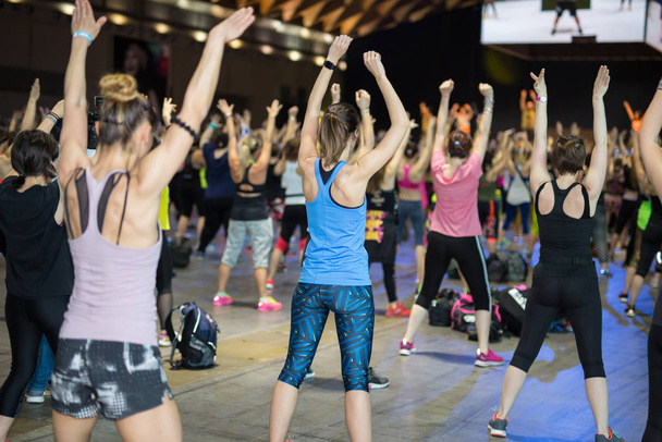 Entrenamiento Fitness en Gimnasio: Personas haciendo Ejercicios en Clase con Música y Profesores en el Escenario
 - Foto, imagen