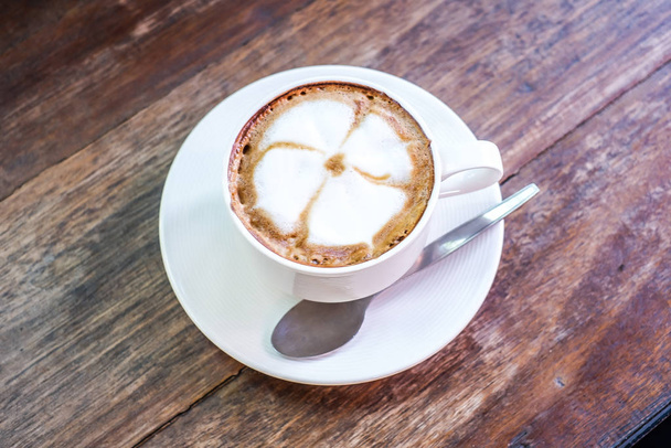 Šálek cappuccino s krásným latte art na dřevěném stole. Ranní káva pro zamilované páry, Hot coffee, Top view. - Fotografie, Obrázek