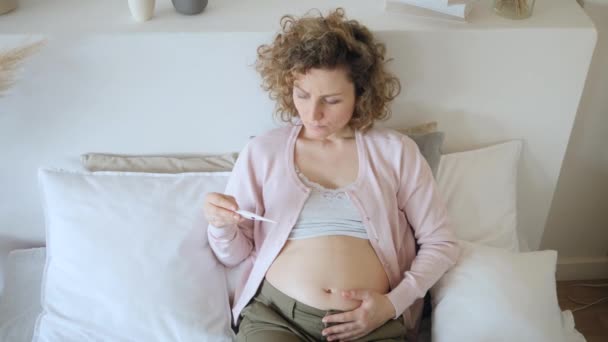 Sad Sick Pregnant Woman Taking Temperature With Thermometer On Bed. - Filmagem, Vídeo