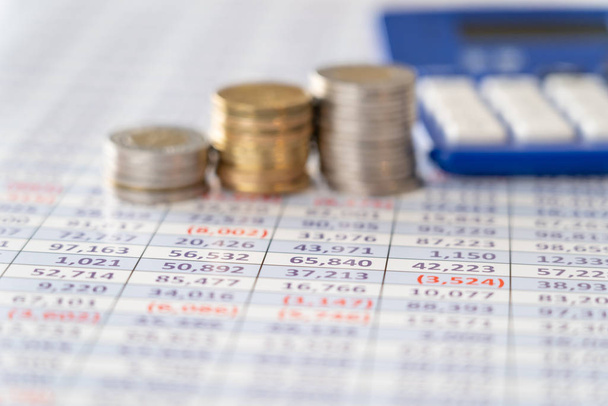 Stack of Coins with Calculator and finacial report Spreadsheet - business concept - Photo, Image