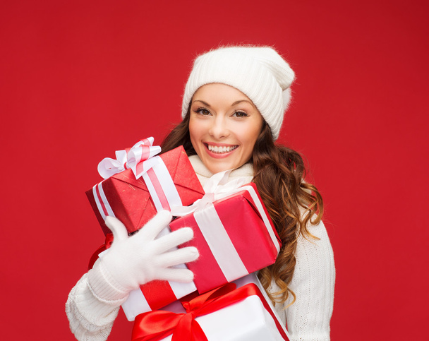 Woman in sweater and hat with many gift boxes - Foto, afbeelding