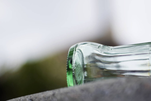 Empty green glass bottle over marble and white background. - Fotó, kép