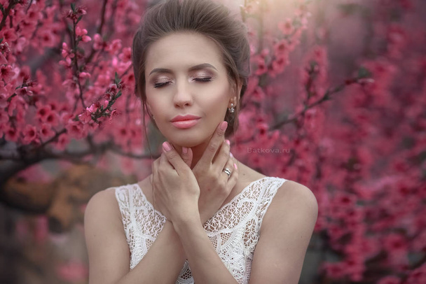 Portrait of a woman close-up on the background of cherry blossoming trees - Photo, Image