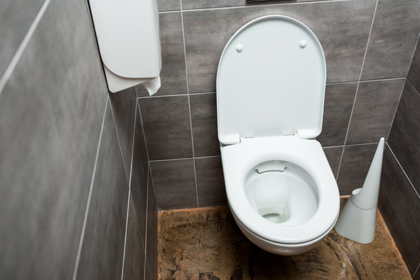 keramische schone toiletpot in modern sanitair met grijze tegel en toiletborstel - Foto, afbeelding
