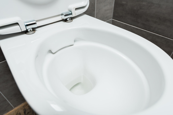 widok z bliska czyste ceramiczne czyste muszli klozetowej w nowoczesnej toalecie z szarą płytką - Zdjęcie, obraz