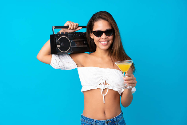 Young woman in summer holidays holding a radio over isolated blu - Photo, Image