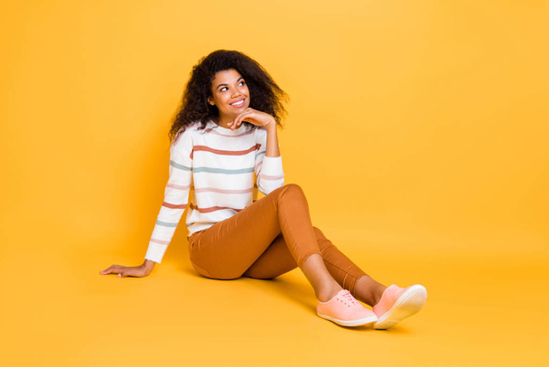 Portrait of her she nice-looking attractive lovely curious cheerful cheery dreamy wavy-haired girl sitting on floor isolated over bright vivid shine vibrant yellow color background - Fotografie, Obrázek