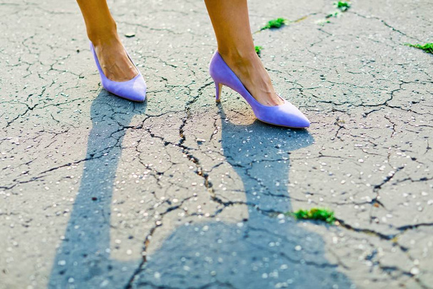 Woman's feet wearing purple high heels, elegant shoes on cracked - Zdjęcie, obraz