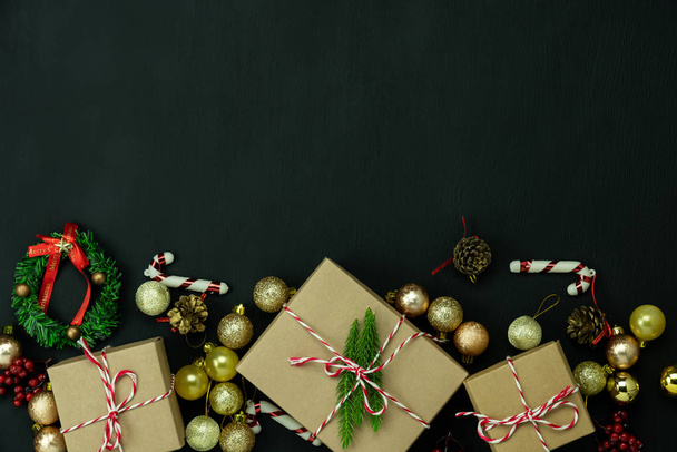 Τραπέζι top view of Merry Christmas decorations & Ευτυχισμένο το νέο έτος στολίδια έννοια.Επίπεδη θέσει ουσιαστική διαφορά αντικείμενα κουτί δώρου & έλατο δέντρο στο σύγχρονο μαύρο χαρτί φόντο στο γραφείο στο σπίτι στούντιο. - Φωτογραφία, εικόνα