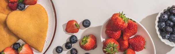 top view of tasty heart shaped pancakes with berries and mint on white background, panoramic shot - Foto, imagen