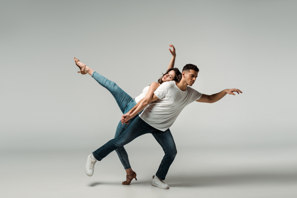 dancers with closed eyes dancing bachata on grey background  - Foto, Imagen
