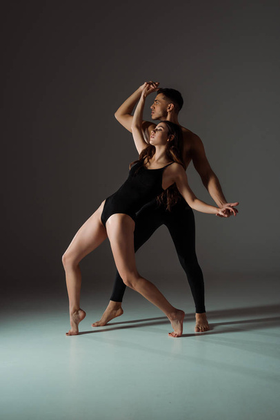 sexy dancers with closed eyes dancing contemporary on dark background  - Photo, Image