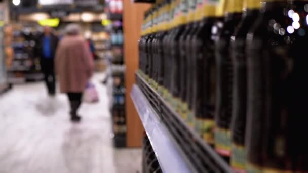 Prodej alkoholu v supermarketu. Řádky a police lahvového piva na výkladní skříni - Záběry, video