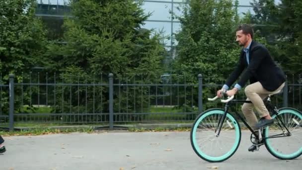 Здоровый взрослый мужчина едет на велосипеде на работу на городской улице, полной бизнесменов
 - Кадры, видео