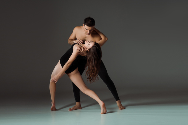 sexy dancers dancing contemporary on dark background with copy space - Фото, изображение