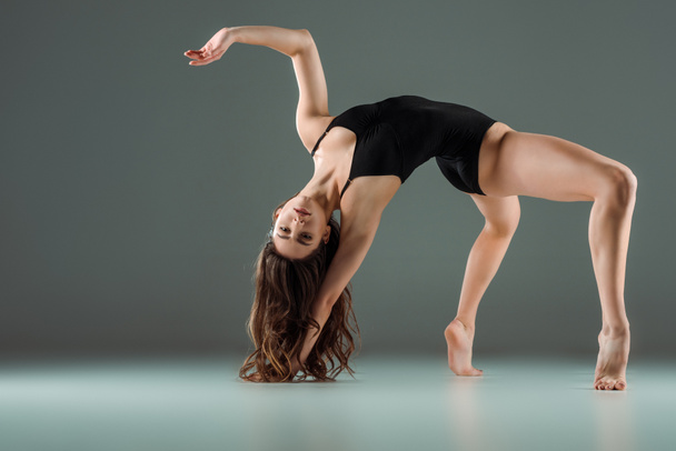 attractive dancer in black bodysuit dancing contemporary on dark background  - Foto, immagini