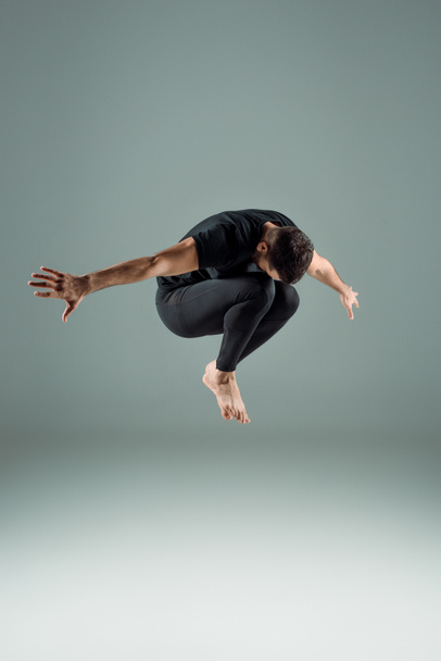 dancer in black leggings and t-shirt dancing contemporary on dark background - Foto, immagini