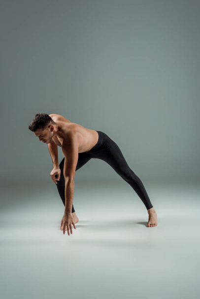 bellissimo ballerino in leggings neri danza contemporanea su sfondo scuro
 - Foto, immagini