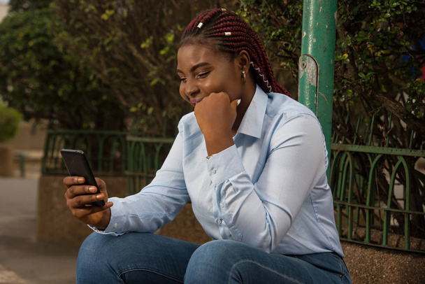 Бізнес-леді розслабляється зі смартфоном на відкритому повітрі
 - Фото, зображення