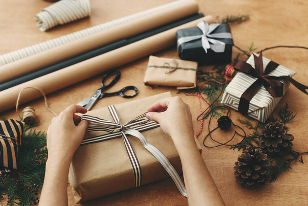 Ręce zawijania stylowe pudełko prezent na Boże Narodzenie w papier rękodzieło i sci - Zdjęcie, obraz