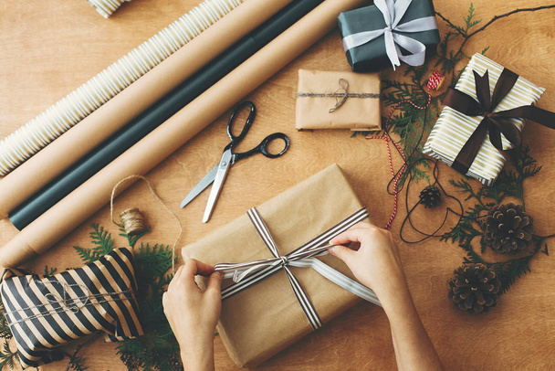 Merry Christmas, flat lay. Hands wrapping stylish christmas gift - Fotoğraf, Görsel