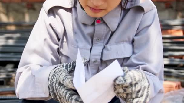  lähikuva naispuolisesta työntekijästä lukemassa kirjettä ja puhdistamassa kyyneleitä auringonvalossa
 - Materiaali, video