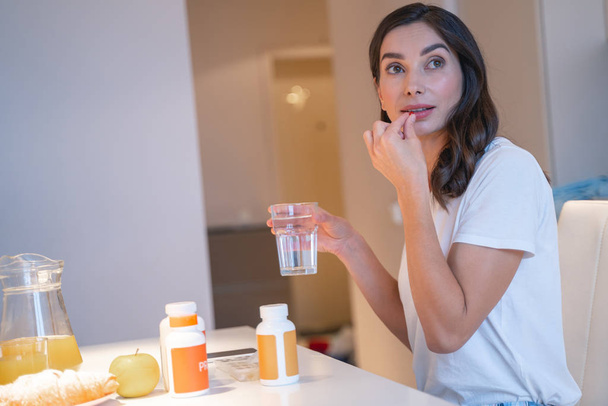 Breakfast and necessary pills for young lady stock photo - Φωτογραφία, εικόνα
