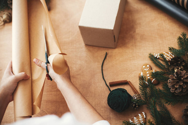 Руки режут оберточную бумагу ножницами и подарочной коробкой, сосна Br
 - Фото, изображение