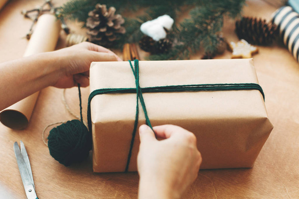 Verpackung stilvolle Weihnachtsgeschenke. Hände wickeln rustikale Weihnacht - Foto, Bild
