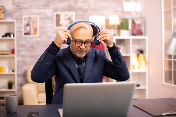 Elderly man in his 60s with headphones on his head - Photo, Image