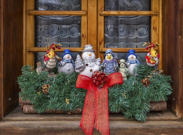 Christmas decoration dolls at the window made of wood - Photo, Image