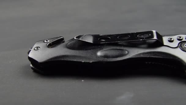 Černý skládací nůž na černém povrchu stolu Ostrá hrana čepele 02 - Záběry, video