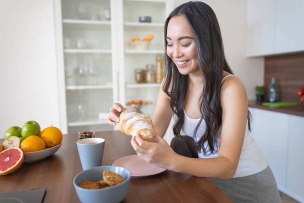 Lady with delicious pastry enjoying her breakfast - Photo, image